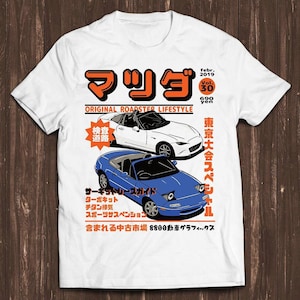 May include: A white short-sleeve t-shirt featuring a graphic print of a white and a blue convertible sports car. The design includes Japanese text, the words "ORIGINAL ROADSTER LIFESTYLE," "febr. 2019," "Vol. 30," and "690 yen" in orange and black.