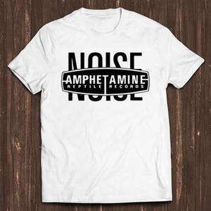 May include: A white short-sleeved t-shirt featuring a black graphic print on the chest. The design includes the word NOISE in large capital letters, overlaid with a black oval emblem containing the text AMPHETAMINE REPTILE RECORDS.