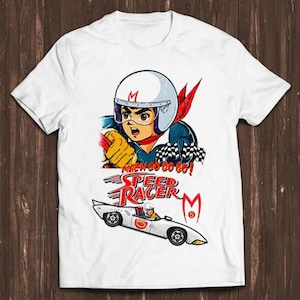 以下が含まれることがあります： スピードレーサーの漫画のイラストが描かれた白いTシャツ。レーシングスーツとヘルメットを着たスピードレーサーが描かれています。Tシャツには「マッハGoGoGo！スピードレーサー」の文字が印刷されています。