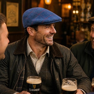 May include: A group of men laughing together in a pub, each holding a pint of Guinness. One man wears a blue tweed flat cap. The pub setting features warm lighting and wooden accents, creating a cozy atmosphere.