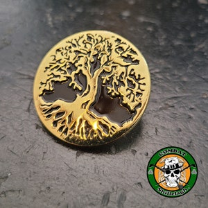 May include: Gold-colored metal pin with a detailed tree of life design. The tree is outlined in black and has a dark brown background.