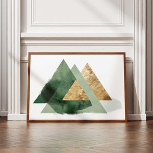 May include: A framed art print featuring three overlapping triangles in shades of green and gold against a white background. The artwork has a modern, abstract design with textured brushstrokes and a wooden frame.