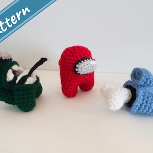 Puede incluir: Tres personajes de Among Us hechos a crochet: un personaje verde con una antena negra, un personaje rojo y un personaje azul con una antena blanca.