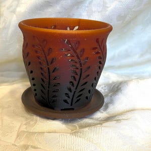 May include: A white ceramic mug with a black handle and the text "But first, coffee" in a black, handwritten-style font. The mug is on a white surface.