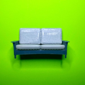 3D printed O scale 1:48 Quarter scale mission style living room sofa, gray and white resin. Can be made in S scale; email me for price