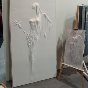 Basrelief, Bild. Spuk von einer Frau aus der Wand.