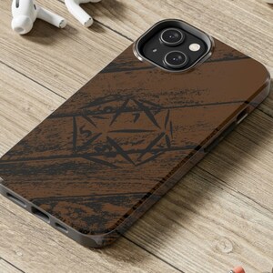 May include: A brown wood-grain phone case with a black and white graphic of a 20-sided die. The case is designed for an iPhone.