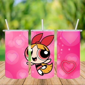 Puede incluir: Un vaso de acero inoxidable rosa con un patrón de corazones rosa y blanco. El vaso presenta una imagen de dibujos animados de una niña con cabello rojo y un lazo rojo. La niña lleva un vestido rojo y amarillo y tiene una gran sonrisa.