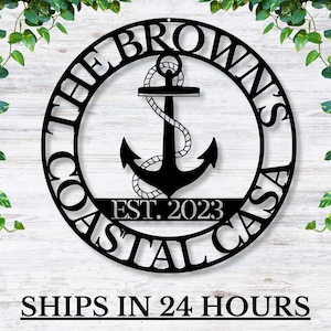 May include: Black metal circular sign with the text "The Browns Coastal Casa Est. 2023" around a black anchor with a rope design.