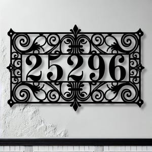May include: Black metal house number plaque with ornate scrollwork and the number 25296.
