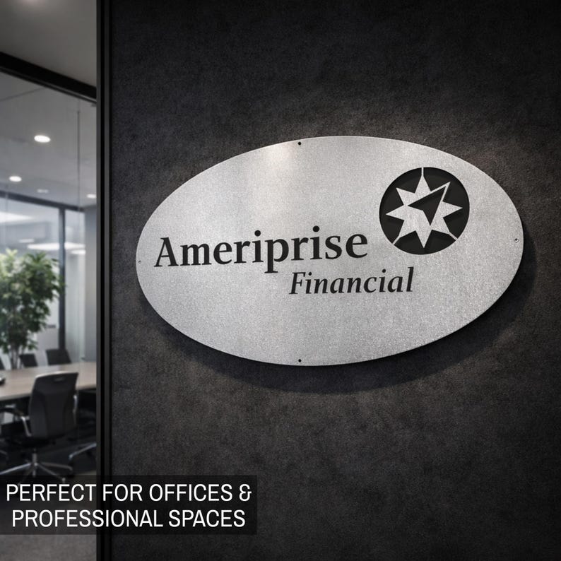 May include: Oval-shaped silver sign with the text "Ameriprise Financial" and a starburst logo. The sign is mounted on a dark gray textured wall. The sign is designed for offices and professional spaces.