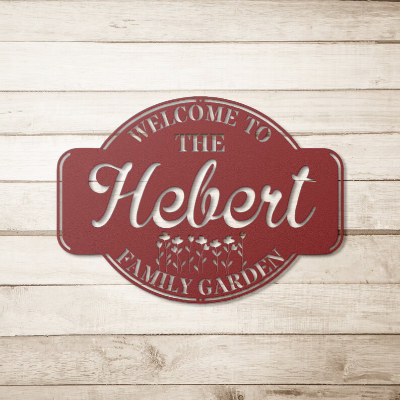 May include: Red metal sign with the text "Welcome to the Hebert Family Garden" in a white, decorative font. The sign has a rounded shape with a floral design.