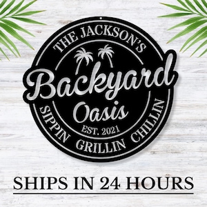May include: Black and silver metal sign with the text "The Jackson's Backyard Oasis Est. 2021 Sippin' Grillin' Chillin'" and palm trees.