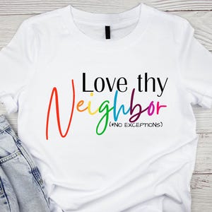 Puede incluir: Camiseta blanca con el texto "Love thy Neighbor (No Exceptions)" en colores arcoíris.