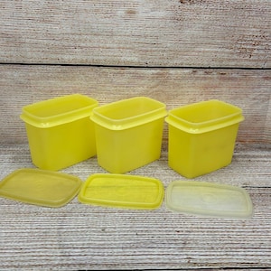 May include: A white ceramic mug with a black handle and the text "But First, Coffee" in a black, handwritten-style font. The mug is on a white surface.