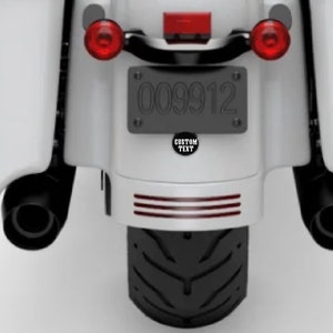 May include: White motorcycle with black exhaust pipes and a black license plate that reads "009912".