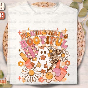 May include: White t-shirt with a retro design featuring the text "MAKING NAILS BOOTIFUL". The design includes a ghost, nail polish bottles, daisies, and a leopard print lightning bolt in shades of orange, pink, and brown.