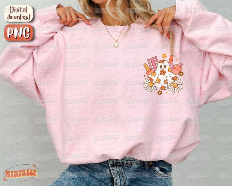 May include: A light pink sweatshirt with a graphic of a ghost with flowers and other objects. The ghost is white with orange and brown accents. The sweatshirt has a relaxed fit and long sleeves. The words "Digital download" and "PNG" are in the upper left corner.