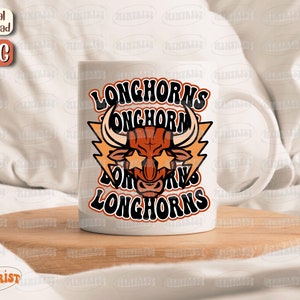 May include: White ceramic mug with a graphic of a brown bull with lightning bolts and the text "Longhorns Longhorn Longhorns" in orange and black.