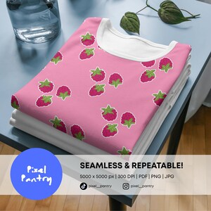 May include: A folded pink t-shirt featuring a repeating pattern of red raspberries with green leaves. The shirt has a white crew neckline. Text on the image reads: SEAMLESS & REPEATABLE! 5000 x 5000 px | 300 DPI | PDF | PNG | JPG. Pixel Pantry.