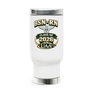 May include: White insulated tumbler with a silver lid and base. The tumbler features the text "BSN RN" above a caduceus symbol and "CLASS OF 2026 UAA" in green, gold, and white. The design is centered on the tumbler.