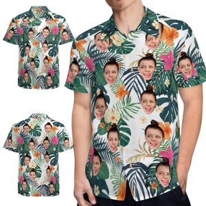May include: A white button-down shirt with a tropical print featuring multiple faces. The shirt has short sleeves and a collared neckline.