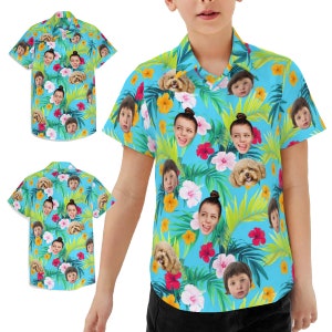 May include: A blue short-sleeved button-down shirt with a tropical print featuring multiple faces and a dog. The shirt has a white collar and a button closure.