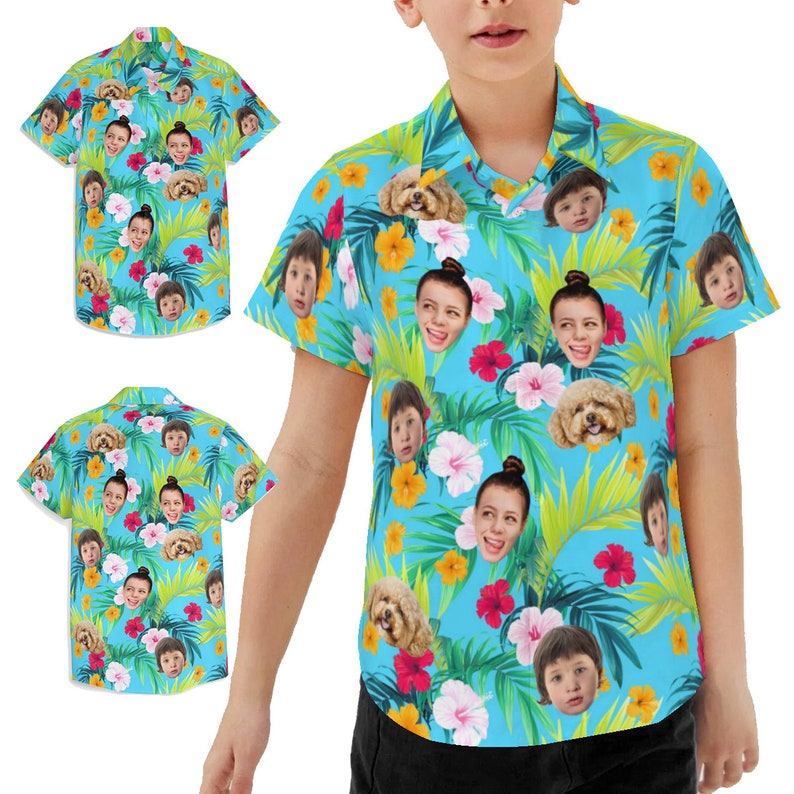 May include: A blue short-sleeved button-down shirt with a tropical print featuring multiple faces and a dog. The shirt has a white collar and a button closure.