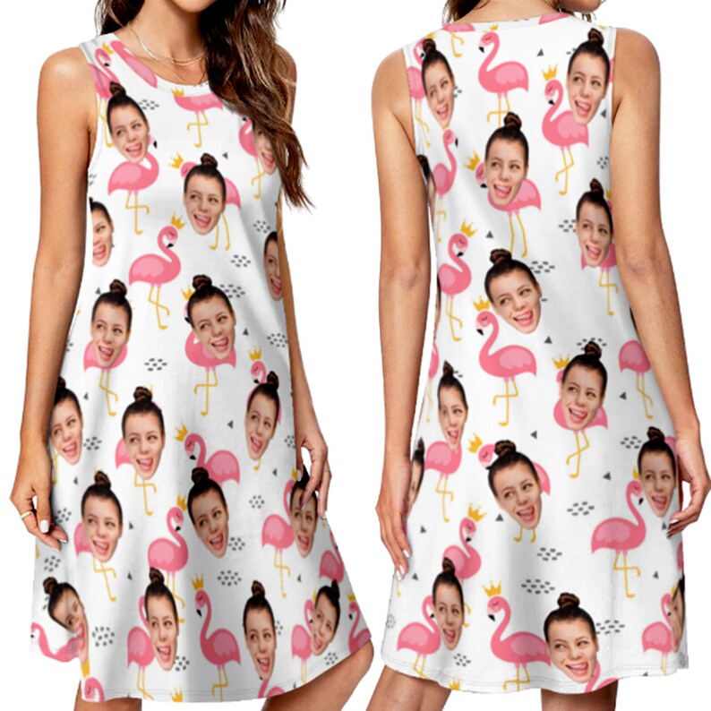 May include: A white sleeveless dress with a pattern of pink flamingos with a person's face on each flamingo's head. The dress has a loose fit and a slightly flared skirt.