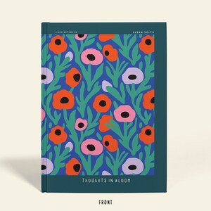 May include: A notebook with a floral pattern. The cover has a blue backdrop with orange, pink, and purple flowers and green leaves. The text "THOUGHTS IN BLOOM" is at the bottom of the cover.
