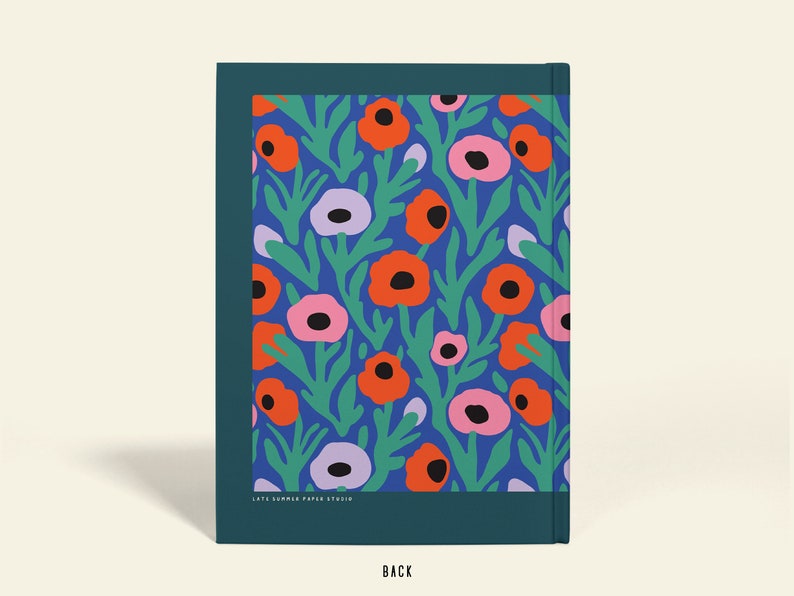 May include: A notebook with a floral design. The cover displays orange, pink, and purple flowers with green leaves on a blue backdrop. The notebook has a dark teal border and the word "BACK" at the bottom.