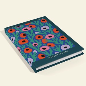 May include: A hardback journal with a floral pattern. The cover displays a blue backdrop with red, pink, and purple flowers and green leaves. The words "THOUGHTS IN BLOOM" are printed on the cover.