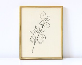 May include: A black and white line drawing of a eucalyptus branch in a gold frame.