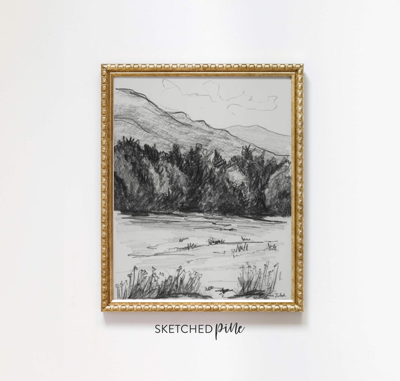 K&ouml;nnte beinhalten: Eine Schwarzwei&szlig;-Bleistiftzeichnung einer Berglandschaft mit einem See im Vordergrund. Die Zeichnung ist in einem goldenen Rahmen mit einem dekorativen Rand gerahmt. Der Text "SKETCHED pine" ist unter dem Rahmen gedruckt.