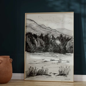 K&ouml;nnte beinhalten: Eine Schwarzwei&szlig;-Bleistiftzeichnung einer Berglandschaft mit einem See im Vordergrund. Die Zeichnung ist in einem goldenen Rahmen gerahmt und unten rechts mit "Veronica Zabel" signiert.
