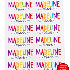 May include: A sheet of vinyl school supply labels featuring the name Madeline Clark in a multi-colored, block-letter font for the first name and a dark blue cursive script for the last name. The text VINYL SCHOOL SUPPY LABEL SHEETS is at the top.