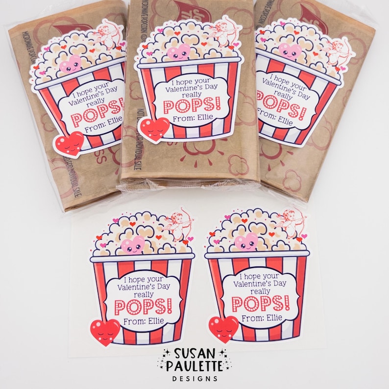 Puede incluir: Bolsas y pegatinas de palomitas para el D&iacute;a de San Valent&iacute;n. Las bolsas de palomitas tienen pegatinas con un dise&ntilde;o de contenedor de palomitas a rayas rojas y blancas. Las pegatinas dicen "&iexcl;Espero que tu D&iacute;a de San Valent&iacute;n realmente EXPLOTE! De: Ellie."