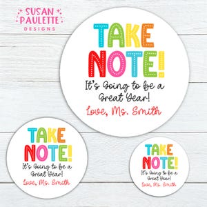 May include: White round stickers with the text "TAKE NOTE! It's Going to be a Great Year! Love, Ms. Smith" in colorful letters. The stickers are in three different sizes, with the largest one in the center.