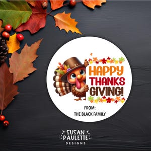 May include: A round Thanksgiving sticker with a cartoon turkey wearing a pilgrim hat and holding a sign that says "Happy Thanksgiving!" The sticker also includes the text "From: The Black Family" and is surrounded by fall leaves.
