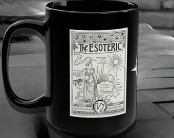 Puede incluir: Taza de cerámica negra con un gráfico blanco de una mujer de pie frente a un sol y un globo terráqueo. El gráfico está rodeado por un borde con el texto "The Esoteric" y "Esoteric Publishing" y "Germany Boston".