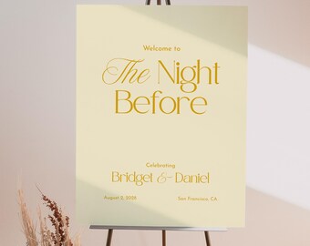 May include: A wedding welcome sign on a black easel. The sign is cream-colored with gold text that reads "Welcome to The Night Before" and the names "Bridget & Daniel" with the date and location.