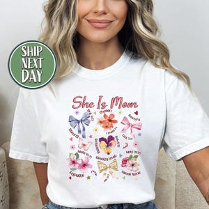 Ona jest mamą chrześcijańska boho kwiatowa koszulka z wersetem biblijnym, koszulka retro chrześcijańska dla mamy, koszulka Blessed Mom, prezent dla mamy Wildflower, koszulka Praying Mama -MD049