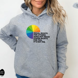 Op de afbeelding: Een grijze hoodie met een regenboog-taartdiagram en de tekst "Gelijke rechten voor anderen betekent niet minder rechten voor jou. Het is geen taart."