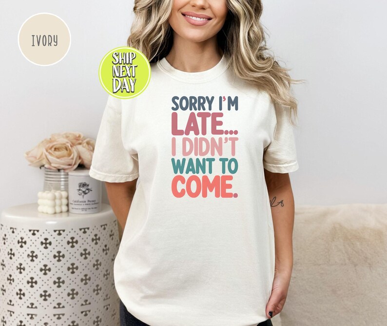 May include: A white t-shirt with the text "Sorry I'm Late... I Didn't Want To Come." in colorful letters.