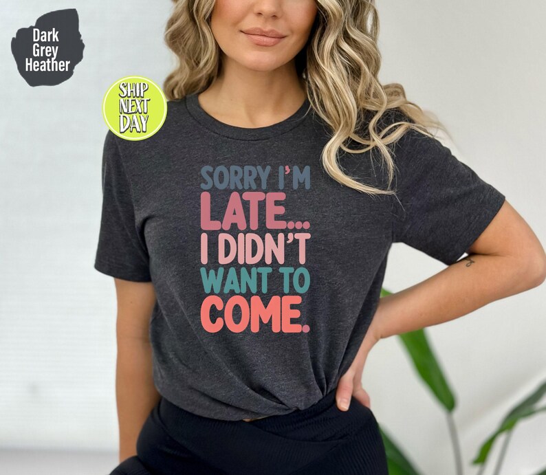 May include: Dark grey heather t-shirt with the text "SORRY I'M LATE... I DIDN'T WANT TO COME." in colorful letters.