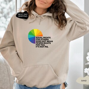 Op de afbeelding: Een zandkleurige hoodie met een regenboog-taartdiagram en de tekst "Gelijke rechten voor anderen betekent niet minder rechten voor jou. Het is geen taart."