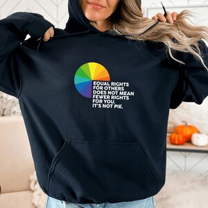 Op de afbeelding: Zwart hoodie met een regenboog-taartdiagram en de tekst "Gelijke rechten voor anderen betekent niet minder rechten voor jou. Het is geen taart."