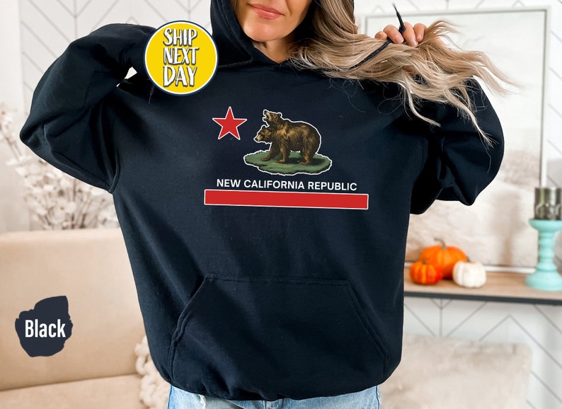 Peut inclure: Sweat-shirt &agrave; capuche noir avec un graphique du drapeau de la R&eacute;publique de Californie repr&eacute;sentant deux ours et le texte "New California Republic".