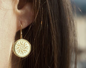 Peut inclure: Boucles d'oreilles en or avec un motif soleil. Le soleil est un motif stylisé avec des rayons émanant du centre.