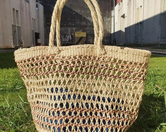 May include: A large, woven tote bag with brown and beige stripes. The bag is made of natural fibers and has a wide, open top.